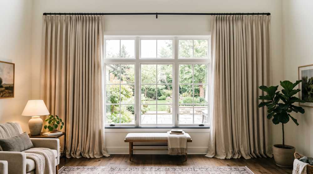 Floor-length curtains hung wide and high above a window